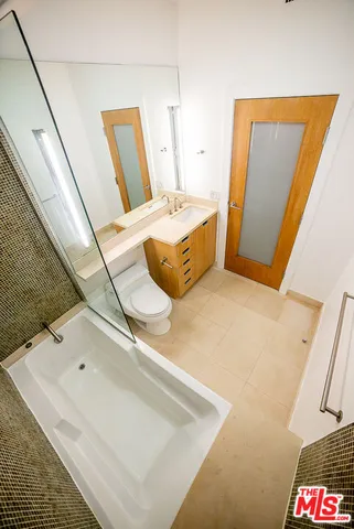 a bathroom with a tub sink and a mirror