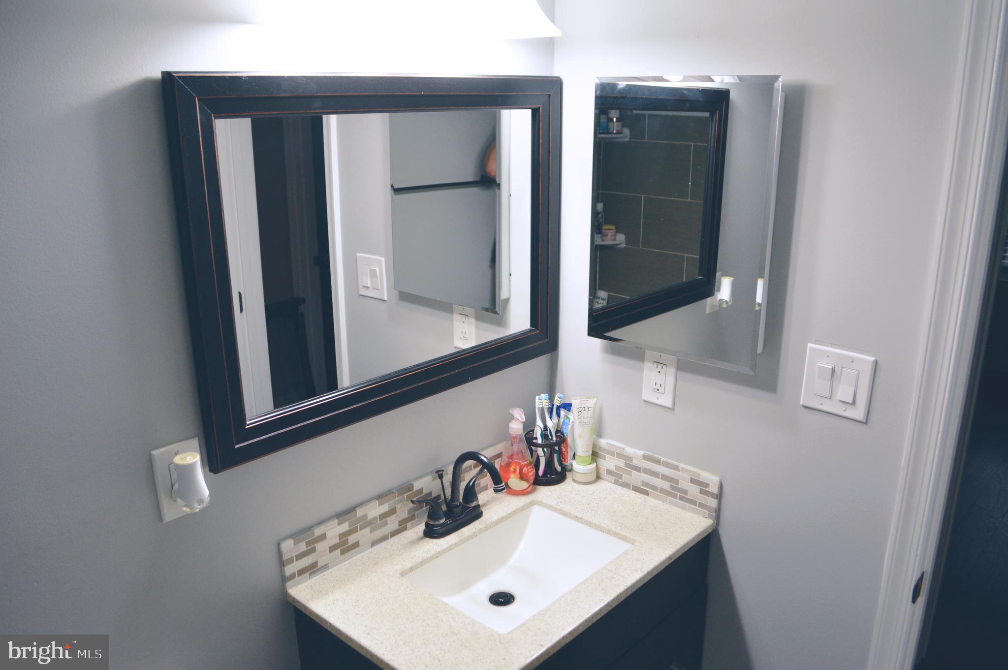 203 Mountain Road Linthicum, MD 21090 - Photo 15 of 17 a bathroom with a sink and a mirror