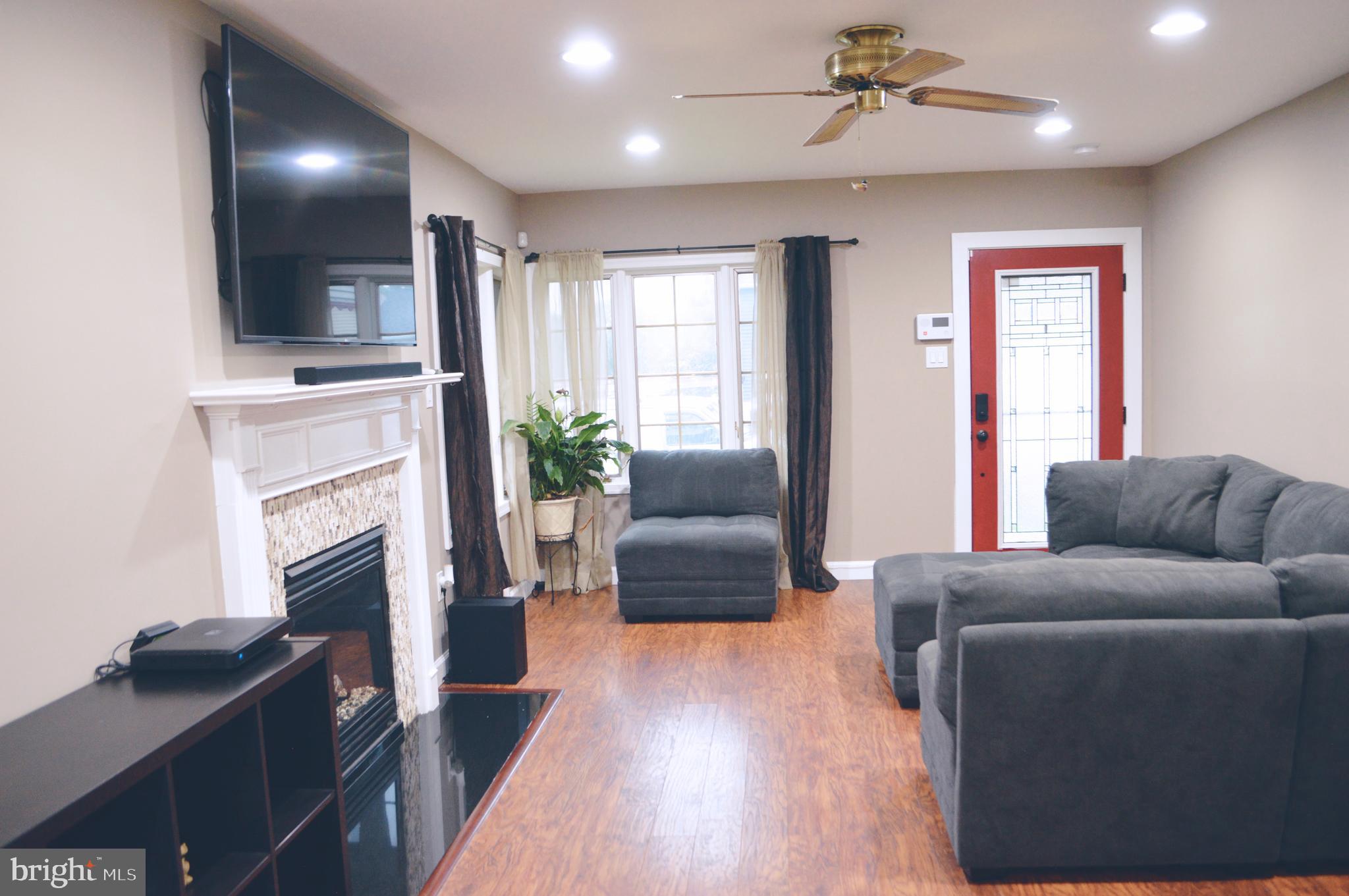 203 Mountain Road Linthicum, MD 21090 - Photo 5 of 17 a living room with furniture a flat screen tv and a fireplace