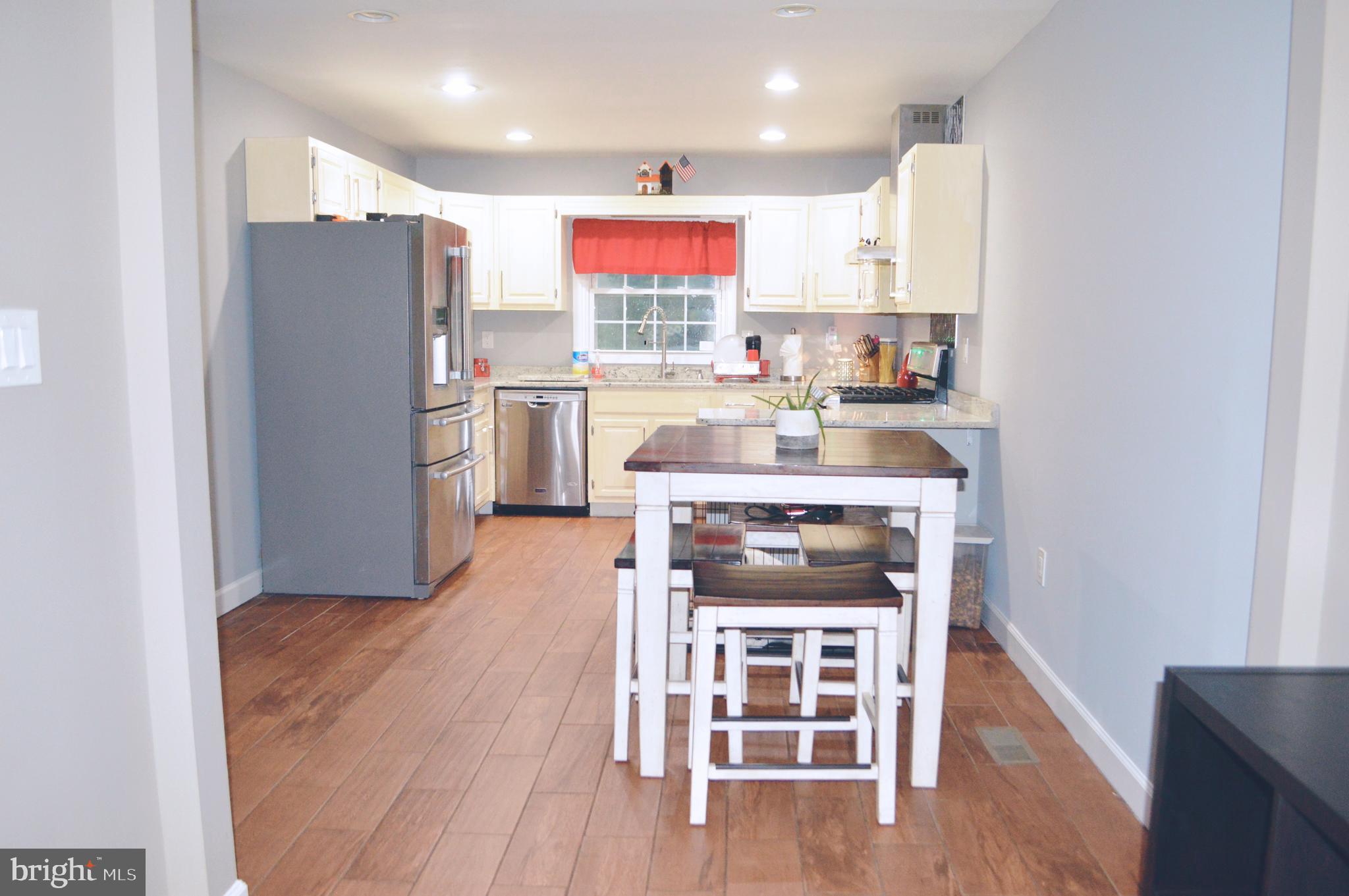 203 Mountain Road Linthicum, MD 21090 - Photo 6 of 17 a kitchen with refrigerator a stove a sink and a refrigerator
