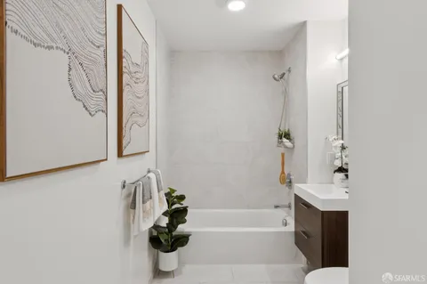 a bathroom with a tub sink and mirror