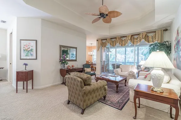 a living room with furniture ceiling fan and a window