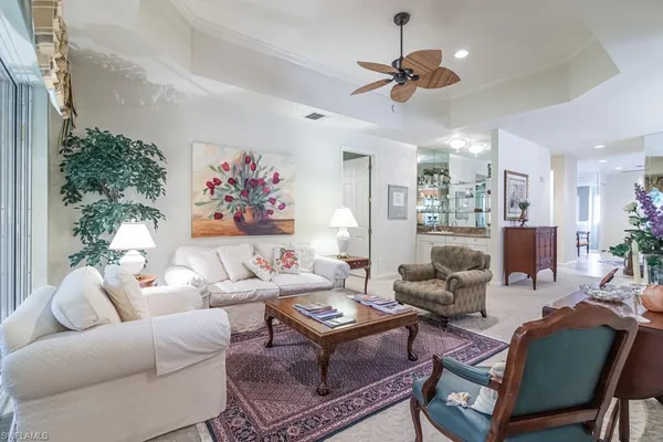 a living room with furniture a ceiling fan and a rug
