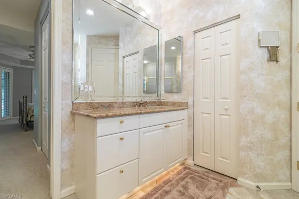 a bathroom with a granite countertop sink and a mirror