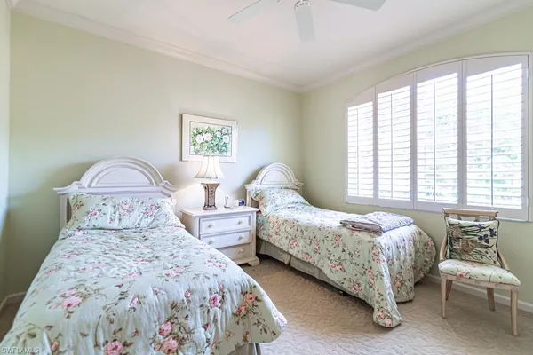 a bedroom with two beds and a large window