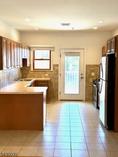 a kitchen with stainless steel appliances granite countertop a refrigerator and a sink