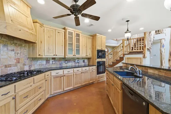 a kitchen with stainless steel appliances granite countertop a stove sink and cabinets