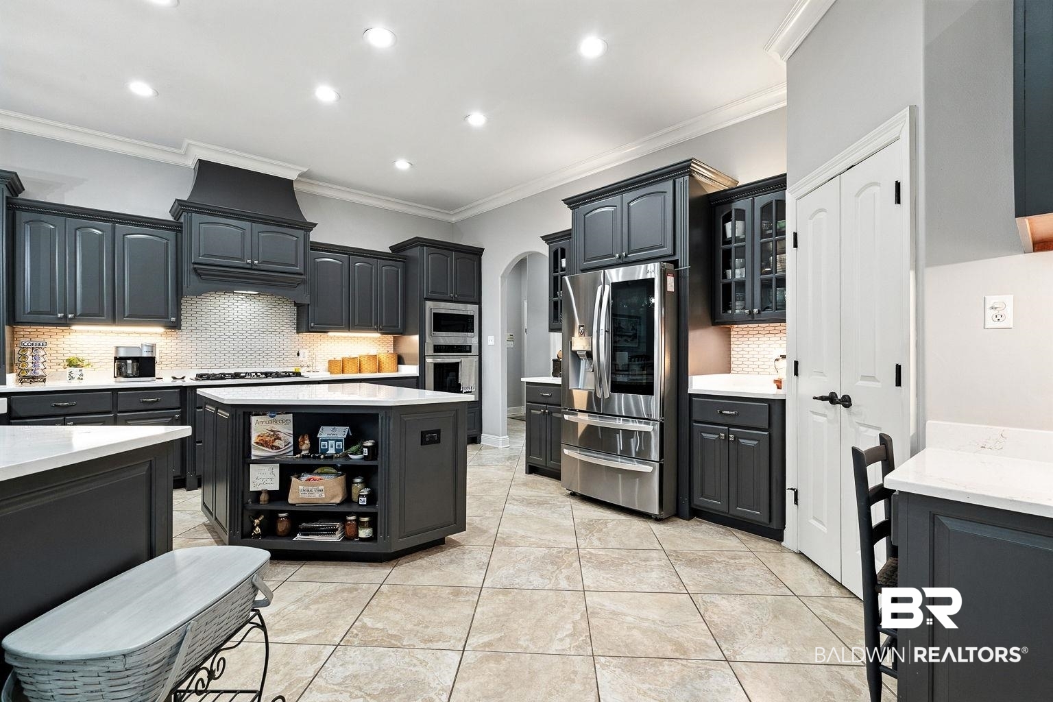 23357 Carnoustie Drive Foley, AL 36535 - Photo 32 of 99 Kitchen featuring arched walkways, decorative backsplash, stainless steel appliances, light countertops, and ornamental molding