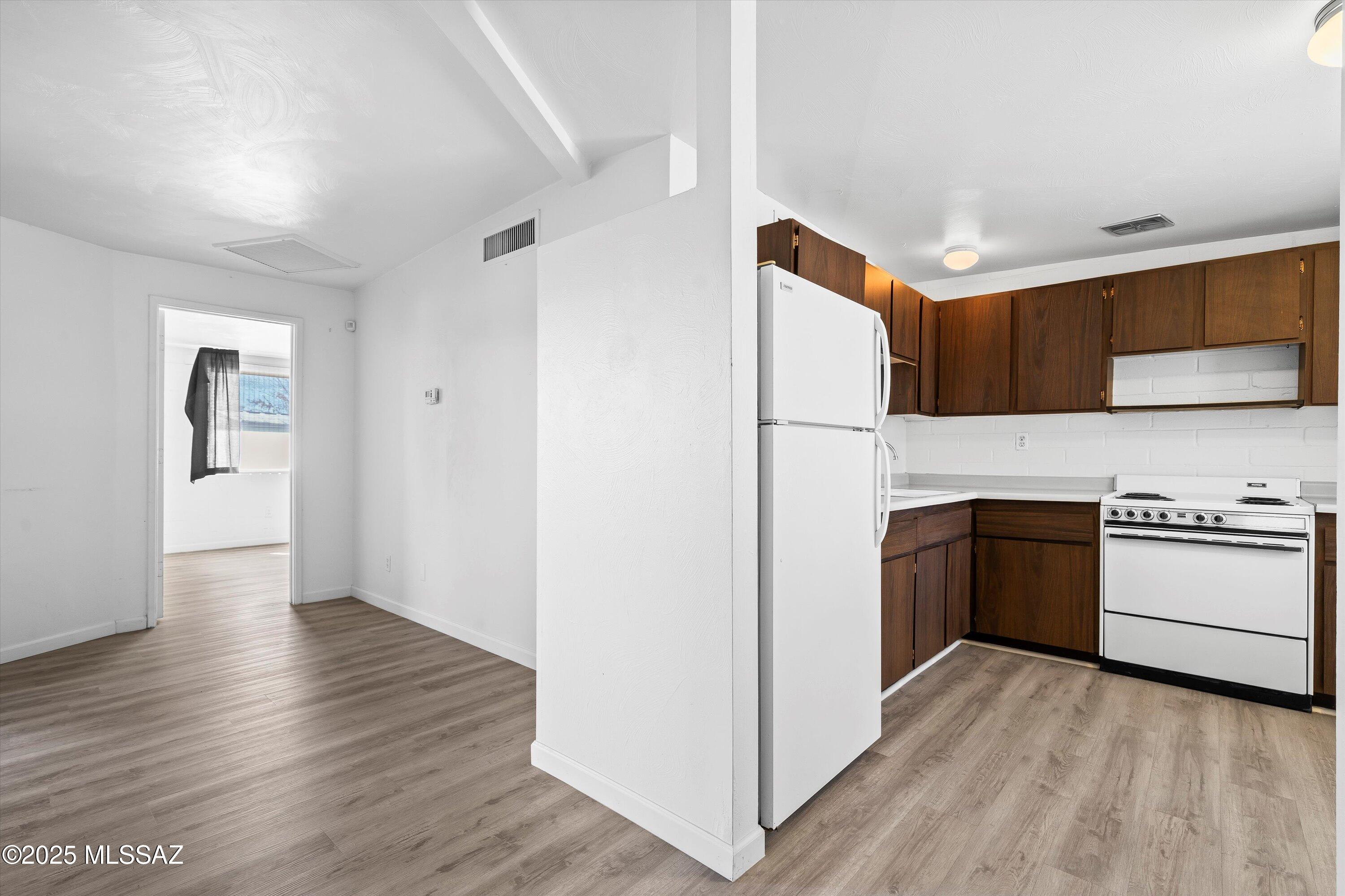 1505 West Roger Road Tucson, AZ 85705 - Photo 9 of 24 a kitchen with granite countertop a stove and a refrigerator