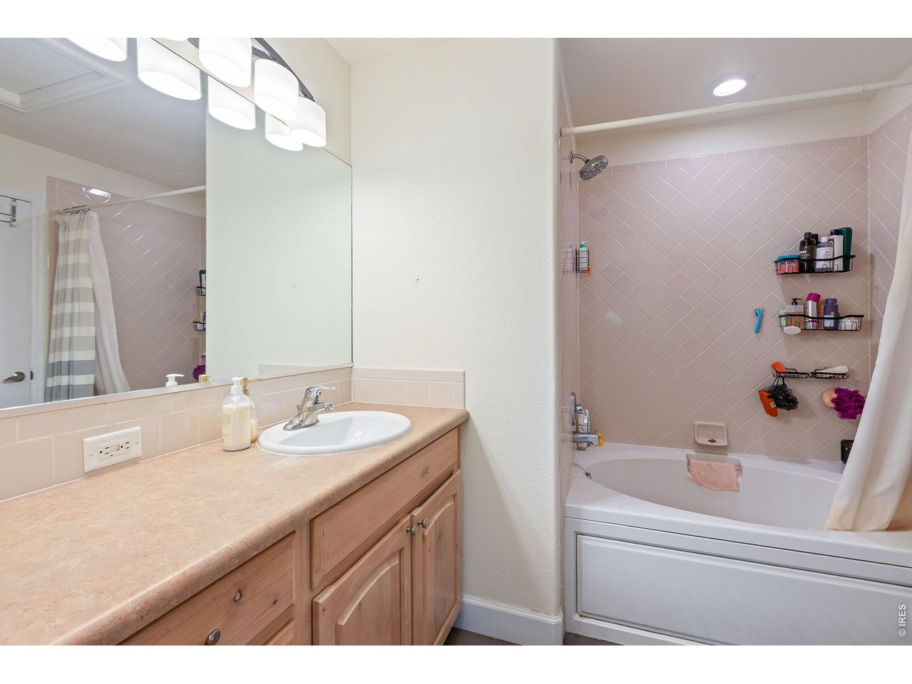 5775 29th Street, Unit 811 Greeley, CO 80634 - Photo 17 of 21 a bathroom with a sink vanity tub and a mirror