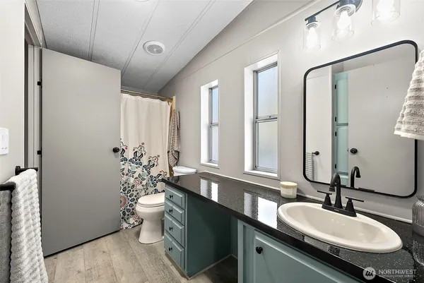 a bathroom with a granite countertop sink and a mirror