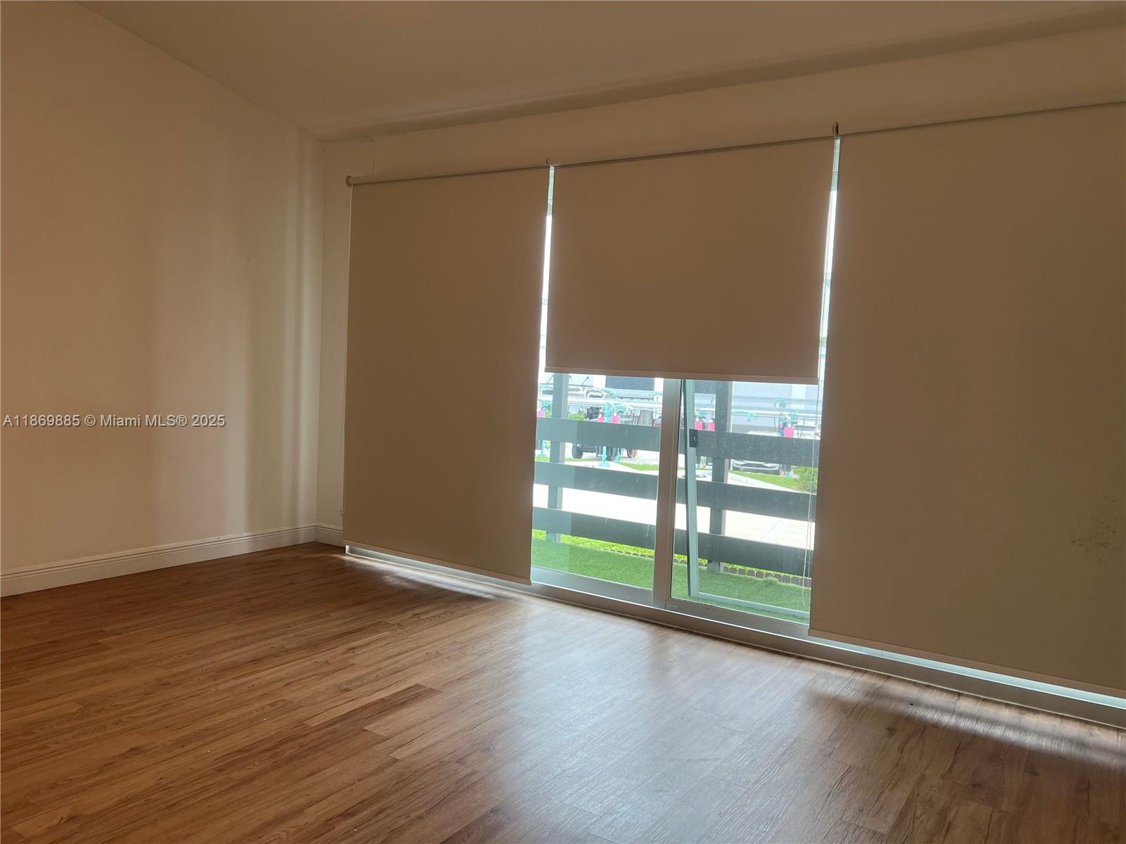 Snapper Creek Townhouses Miami, FL 33173 - Photo 12 of 20 a view of an empty room with wooden floor and a window