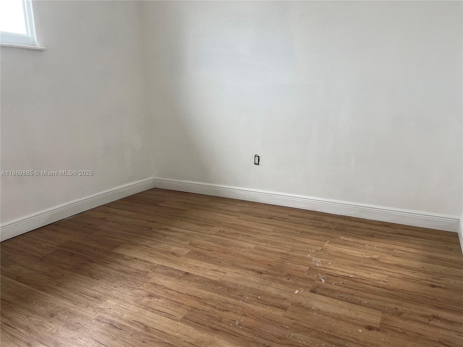 Snapper Creek Townhouses Miami, FL 33173 - Photo 16 of 20 a view of an empty room with wooden floor and a window