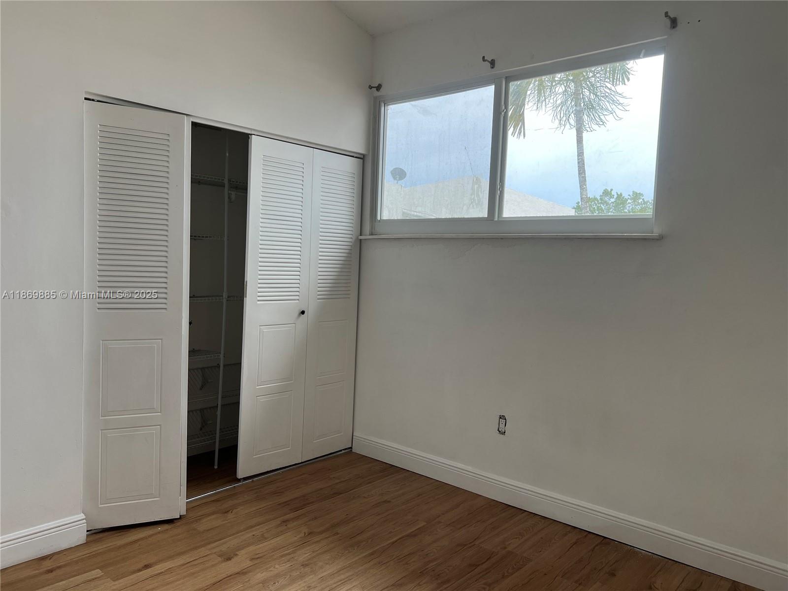 Snapper Creek Townhouses Miami, FL 33173 - Photo 17 of 20 an empty room with wooden floor and windows