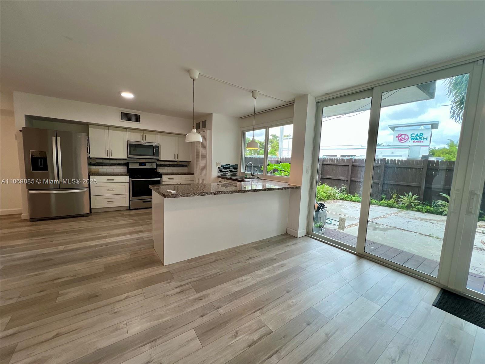 Snapper Creek Townhouses Miami, FL 33173 - Photo 5 of 20 a kitchen with stainless steel appliances wooden floors and wooden cabinets