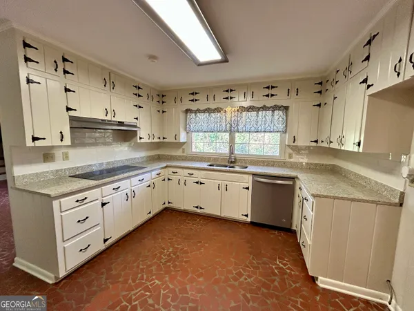 a kitchen with granite countertop a sink stove and cabinets