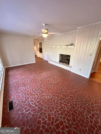 a view of empty room with a fireplace and window