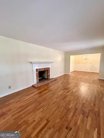 an empty room with wooden floor and a window