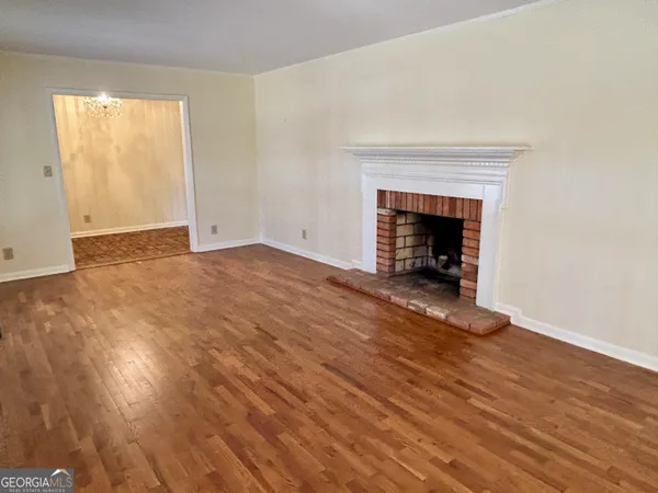 an empty room with wooden floor and a fireplace