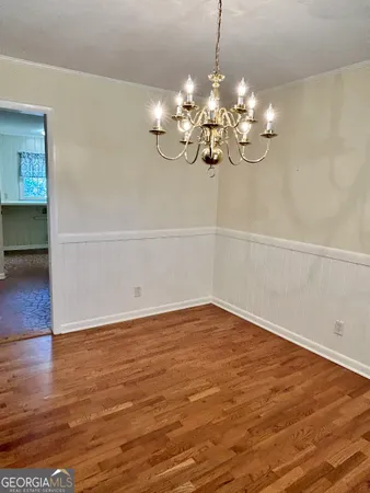 a view of a room with wooden floor and chandelier