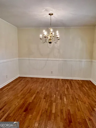 a view of a room with wooden floor and chandelier