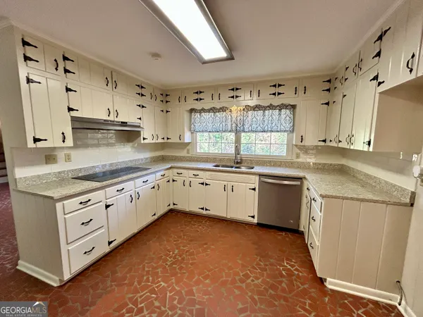 a kitchen with granite countertop a sink stainless steel appliances and cabinets