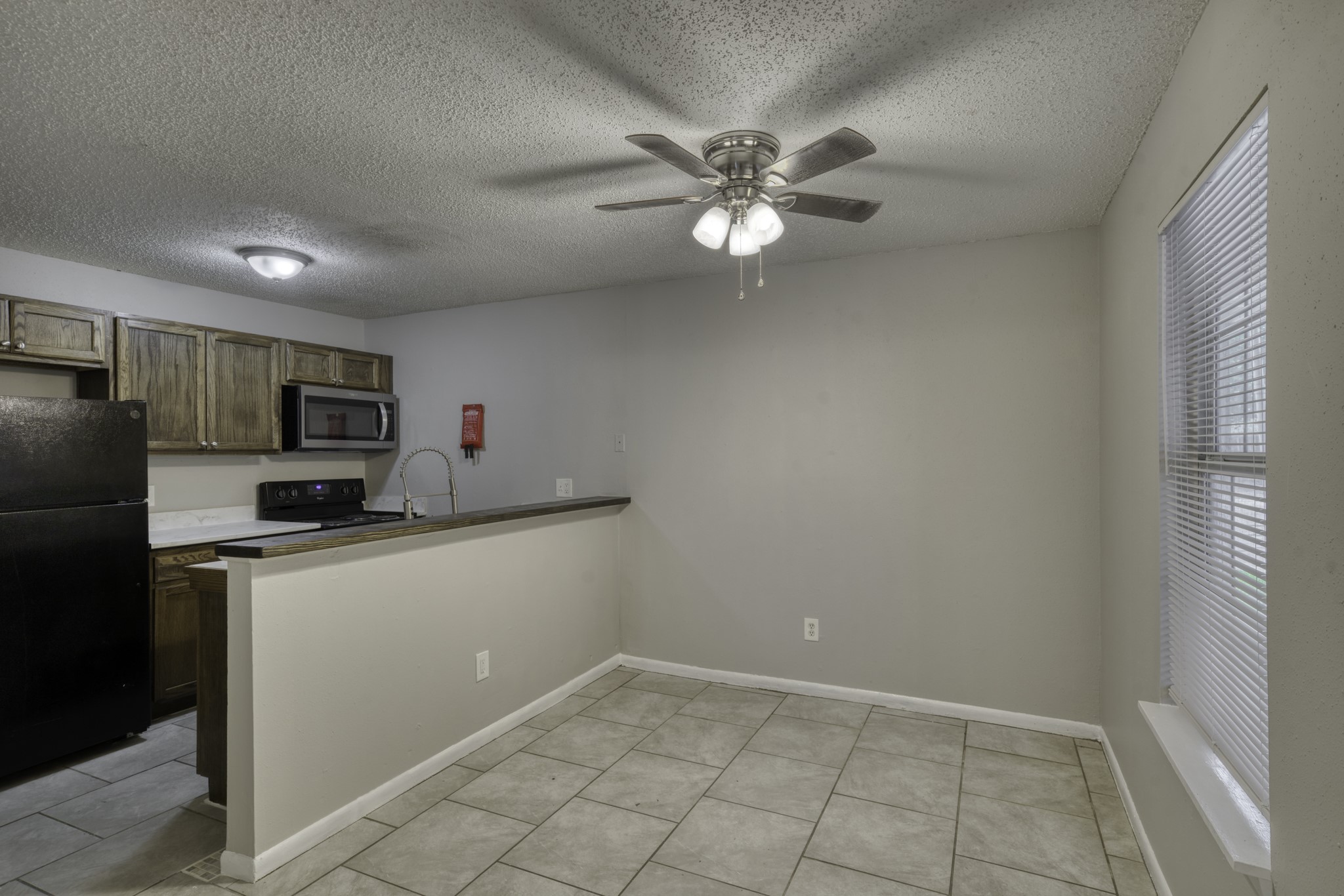 2000 Kazmeier Plaza Bryan, TX 77802 - Photo 15 of 23 a kitchen with granite countertop a refrigerator a stove a microwave and white cabinets