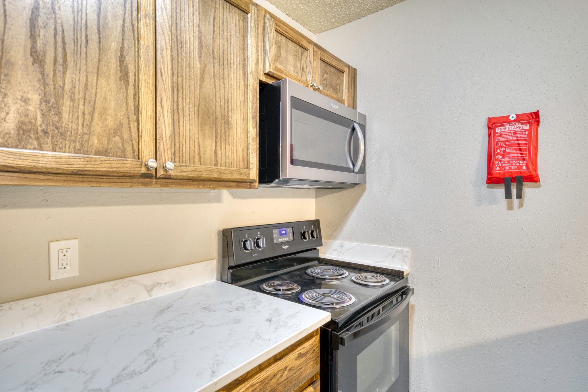2000 Kazmeier Plaza Bryan, TX 77802 - Photo 18 of 23 a kitchen with granite countertop cabinets stainless steel appliances and a wooden floor
