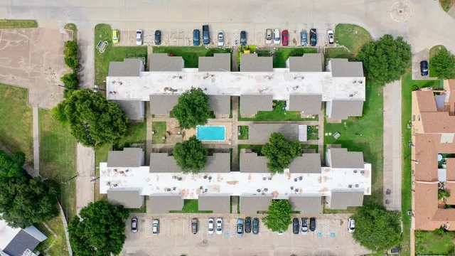 a aerial view of a house with yard and large trees