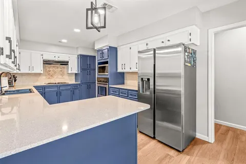 a kitchen with stainless steel appliances a refrigerator and a counter space