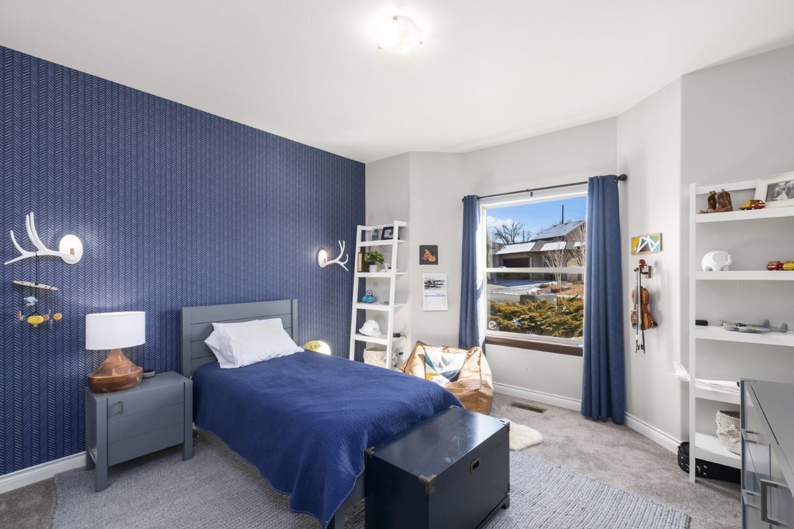 744 Ruby Ranch Drive Grand Junction, CO 81505 - Photo 22 of 33 a bedroom with furniture and a book shelf