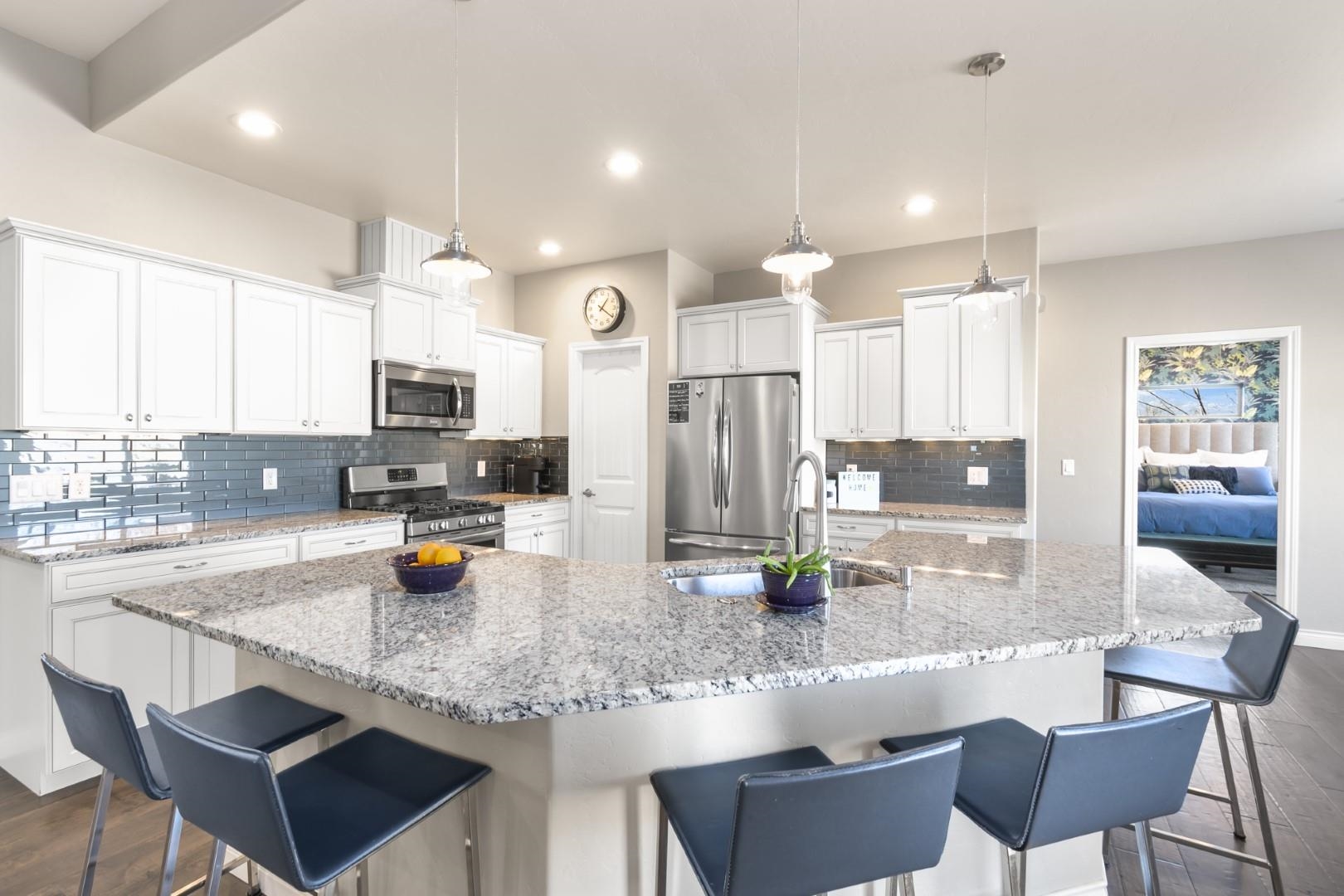 744 Ruby Ranch Drive Grand Junction, CO 81505 - Photo 8 of 33 a kitchen with stainless steel appliances granite countertop a sink a stove a refrigerator cabinets and chairs