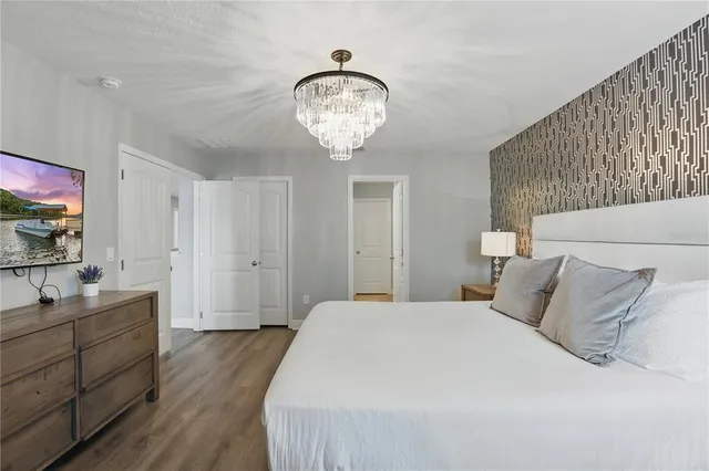 a spacious bedroom with a bed and a chandelier