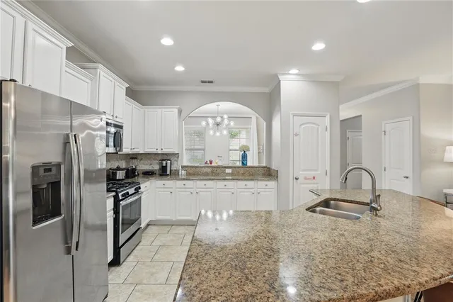 a kitchen with granite countertop kitchen island stainless steel appliances a table and chairs