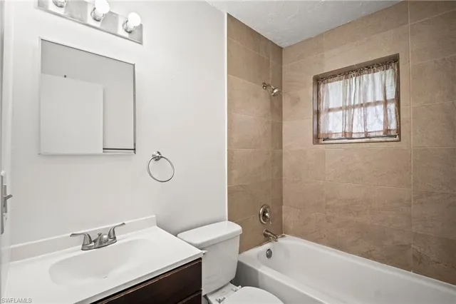a bathroom with a sink vanity tub and toilet