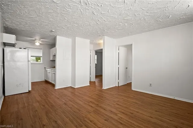 a view of a kitchen with wooden floor and a refrigerator