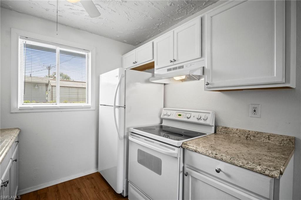 3215 Jeffcott Street Fort Myers, FL 33916 - Photo 26 of 33 Kitchen with white electric range oven, under cabinet range hood, dark wood-type flooring, white cabinetry, and a ceiling fan