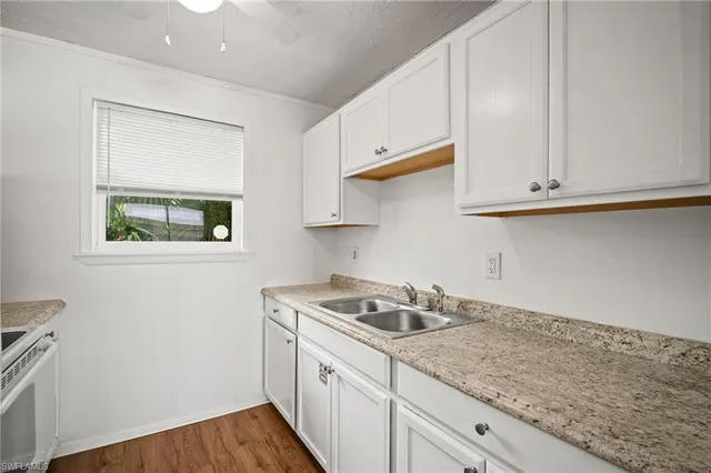 a kitchen with granite countertop white cabinets and a stove