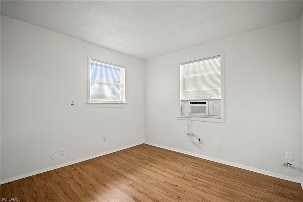 3215 Jeffcott Street Fort Myers, FL 33916 - Photo 9 of 33 Spare room with wood finished floors and cooling unit