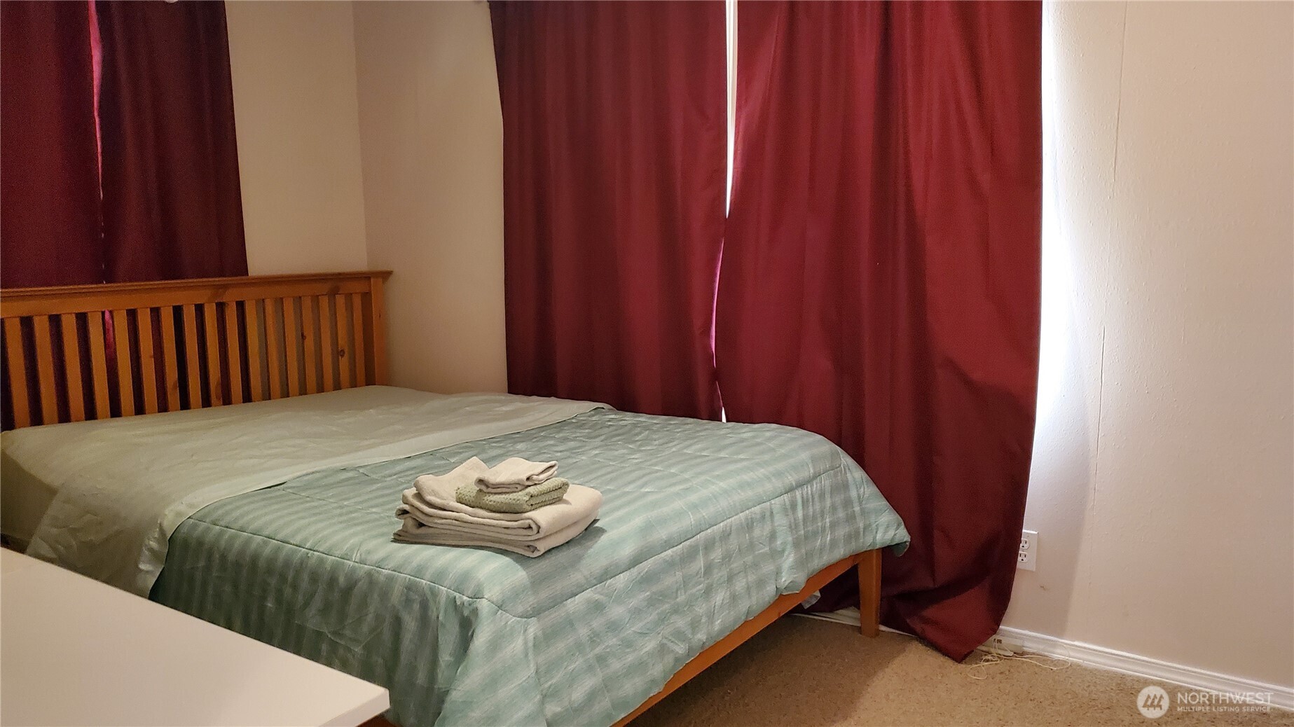 25619 Camp 12 Road Leavenworth, WA 98826 - Photo 21 of 29 a bed sitting in a bedroom next to a wooden wall