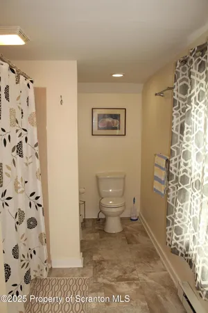 a bathroom with a toilet and a shower curtain