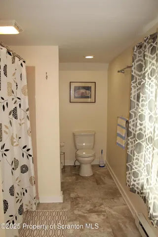 a bathroom with a toilet and a shower curtain