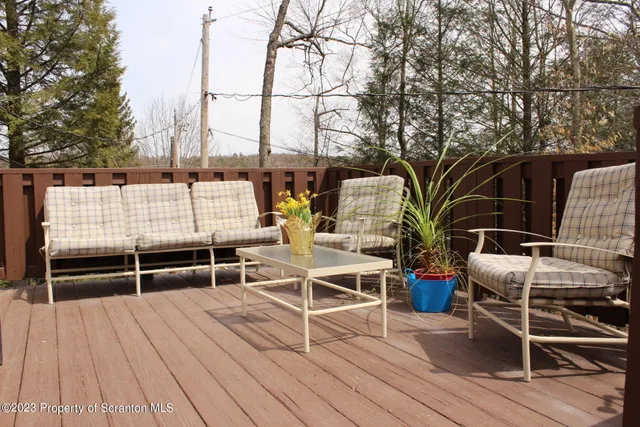 a roof deck with table and chairs and wooden floor