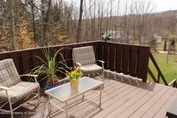 a roof deck with chairs and wooden floor