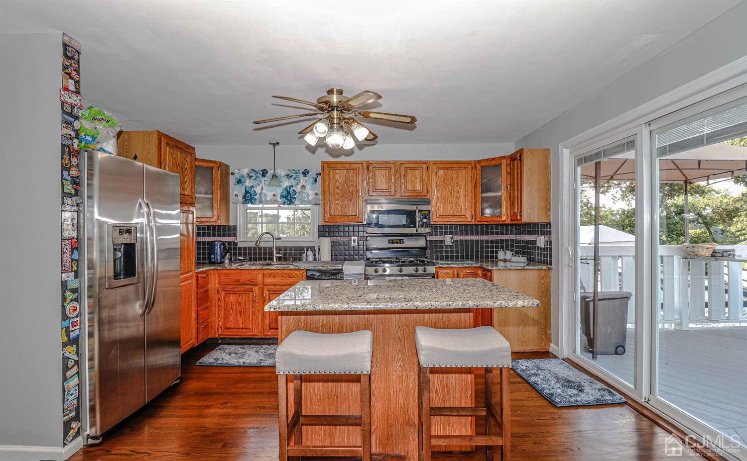 12 Bowser Road New Brunswick, NJ 08901 - Photo 6 of 21 a kitchen with stainless steel appliances granite countertop a stove top oven a refrigerator and a dining table view