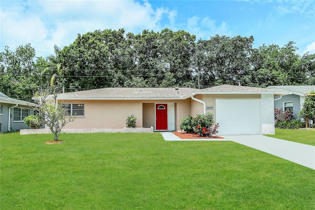 a front view of house with a garden and yard