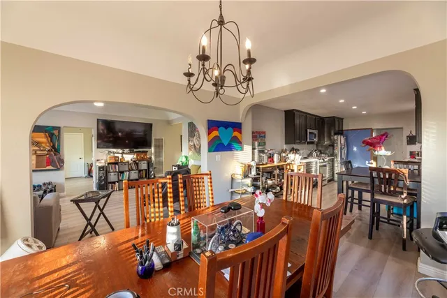 a view of a dining room and livingroom with furniture wooden floor a chandelier