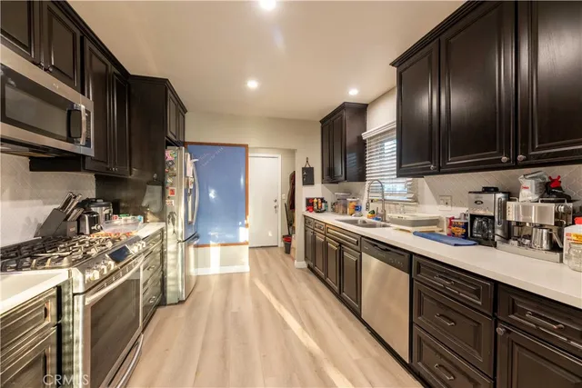 a kitchen with stainless steel appliances granite countertop lots of counter top space a sink and cabinets