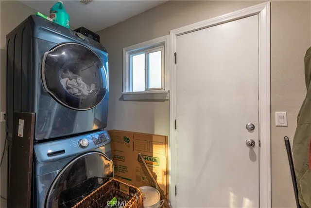 a view of a bathroom with washing machine and a mirror
