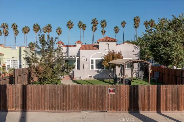 a view of a house with wooden fence